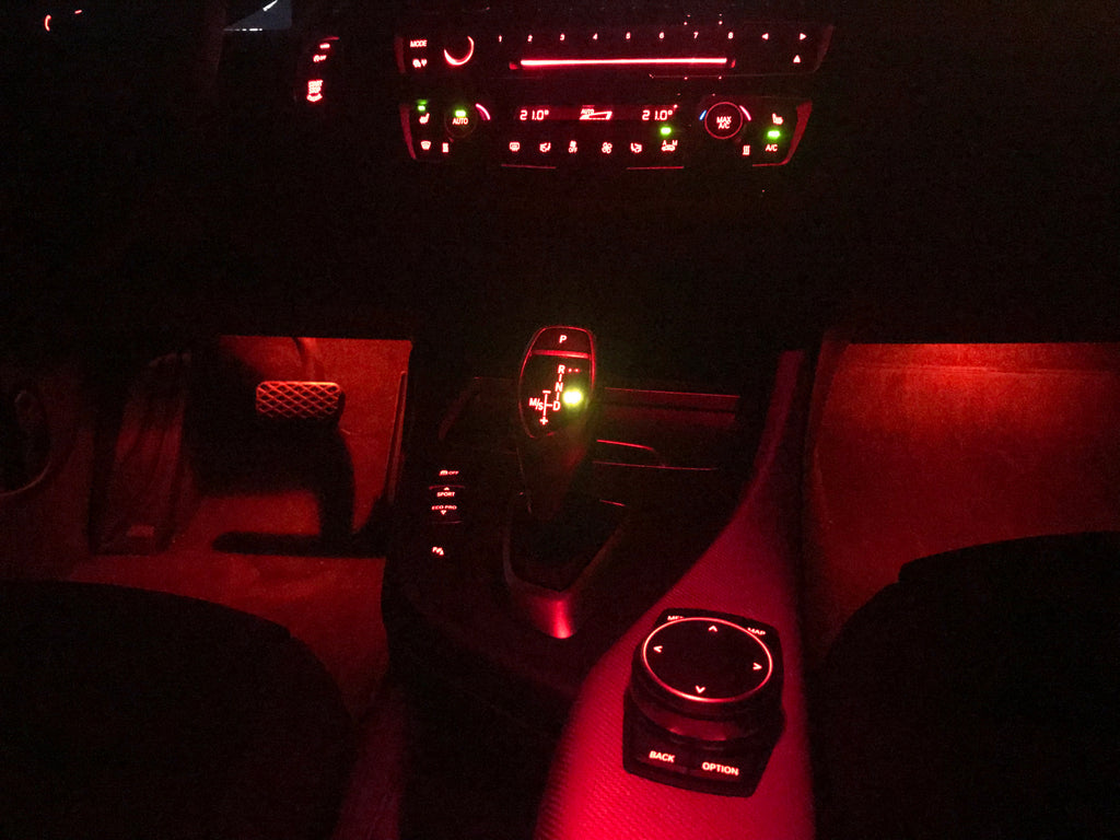 Red ambient BMW F-Series footwell lighting shown after installation